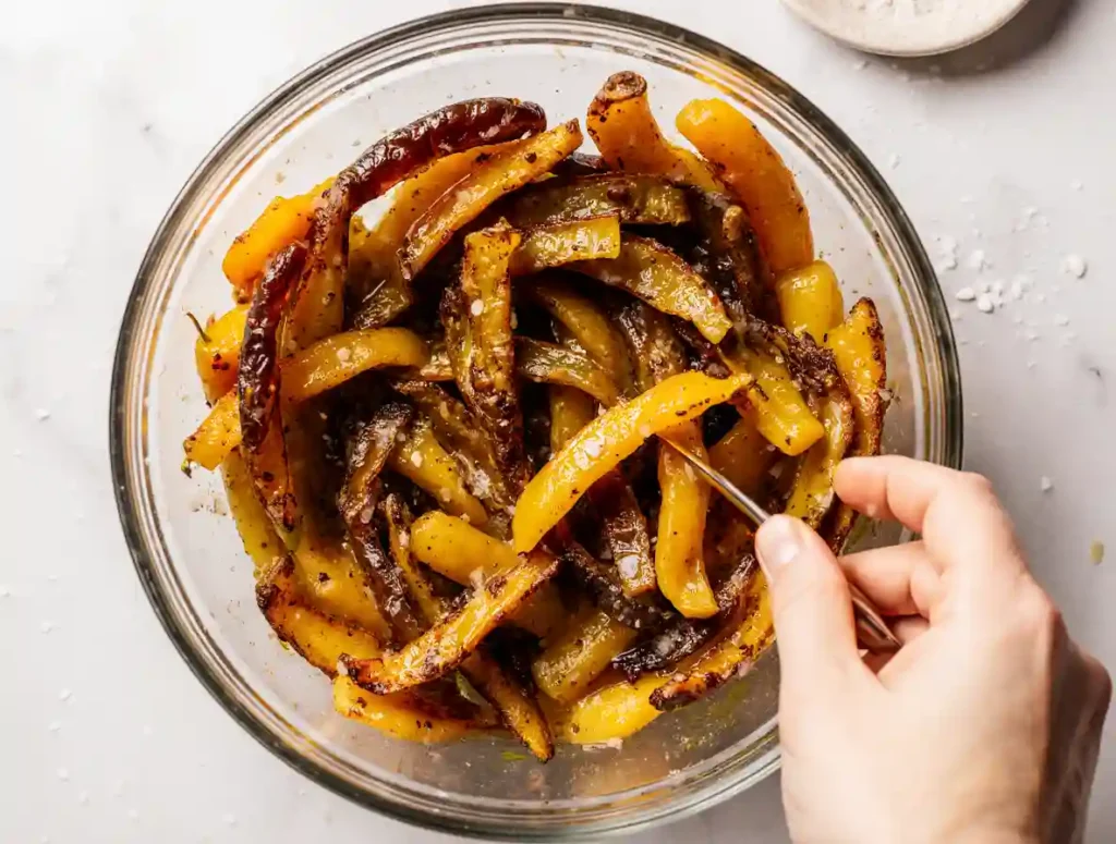 Tossing shishito peppers in oil for air frying