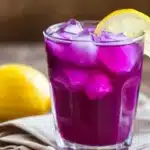 Purple cabbage juice in pitcher and glass with fresh ingredients