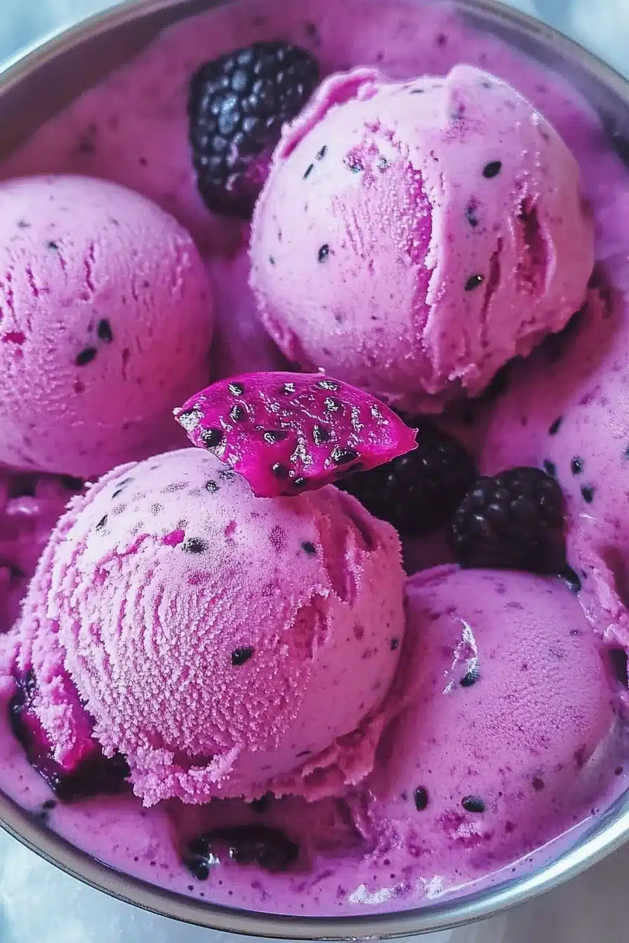 Colorful Dragon Fruit Ice Cream in a bowl garnished with fresh fruit