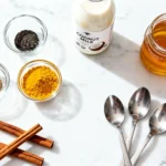 Pepper Trick For Neuropathy Recipe: 5 Powerful Steps to Natural Relief 12 Turmeric milk ingredients including turmeric powder, black pepper, coconut milk, and honey on white marble
