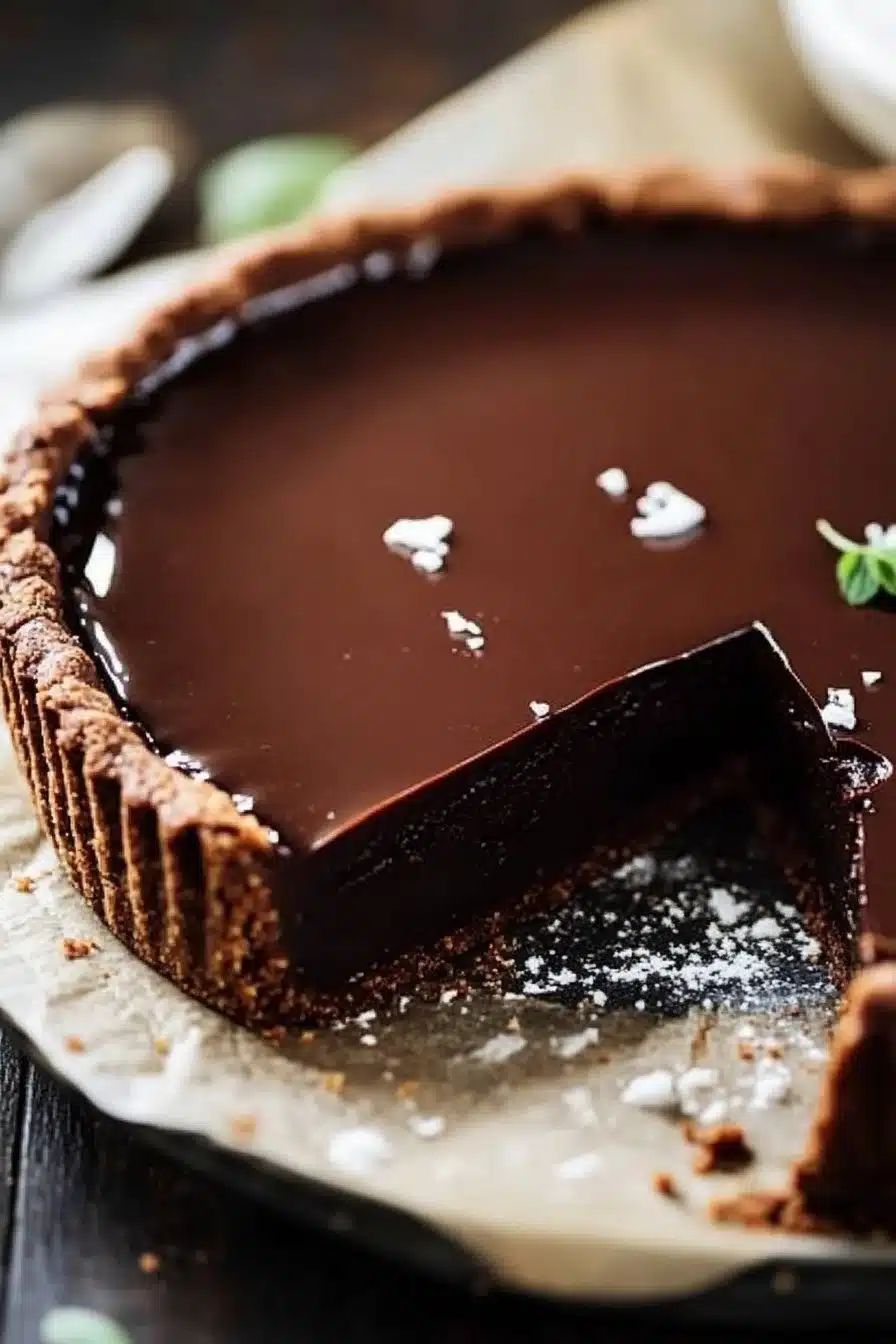 Delicious chocolate ganache tart with a rich and smooth chocolate topping.