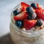 Low calorie overnight oats recipe served in a glass jar with berries and cinnamon