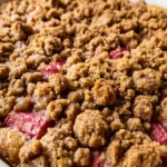 Freshly baked rhubarb coffee cake recipe in white square pan with thick golden brown sugar streusel topping
