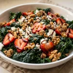 Finished strawberry kale salad recipe bowl close up with feta walnuts granola and balsamic glaze